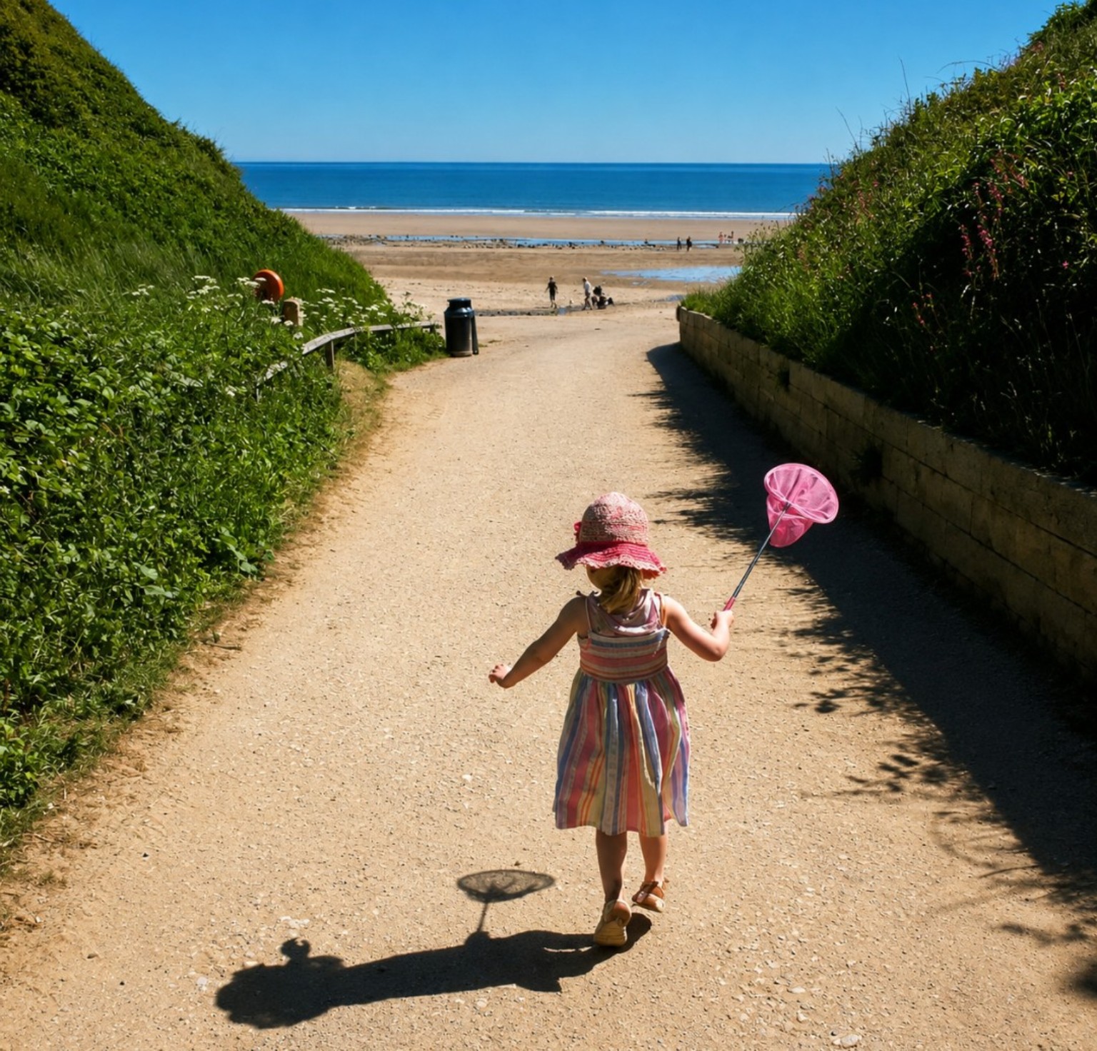Child walking toward the beach carrying a pink net