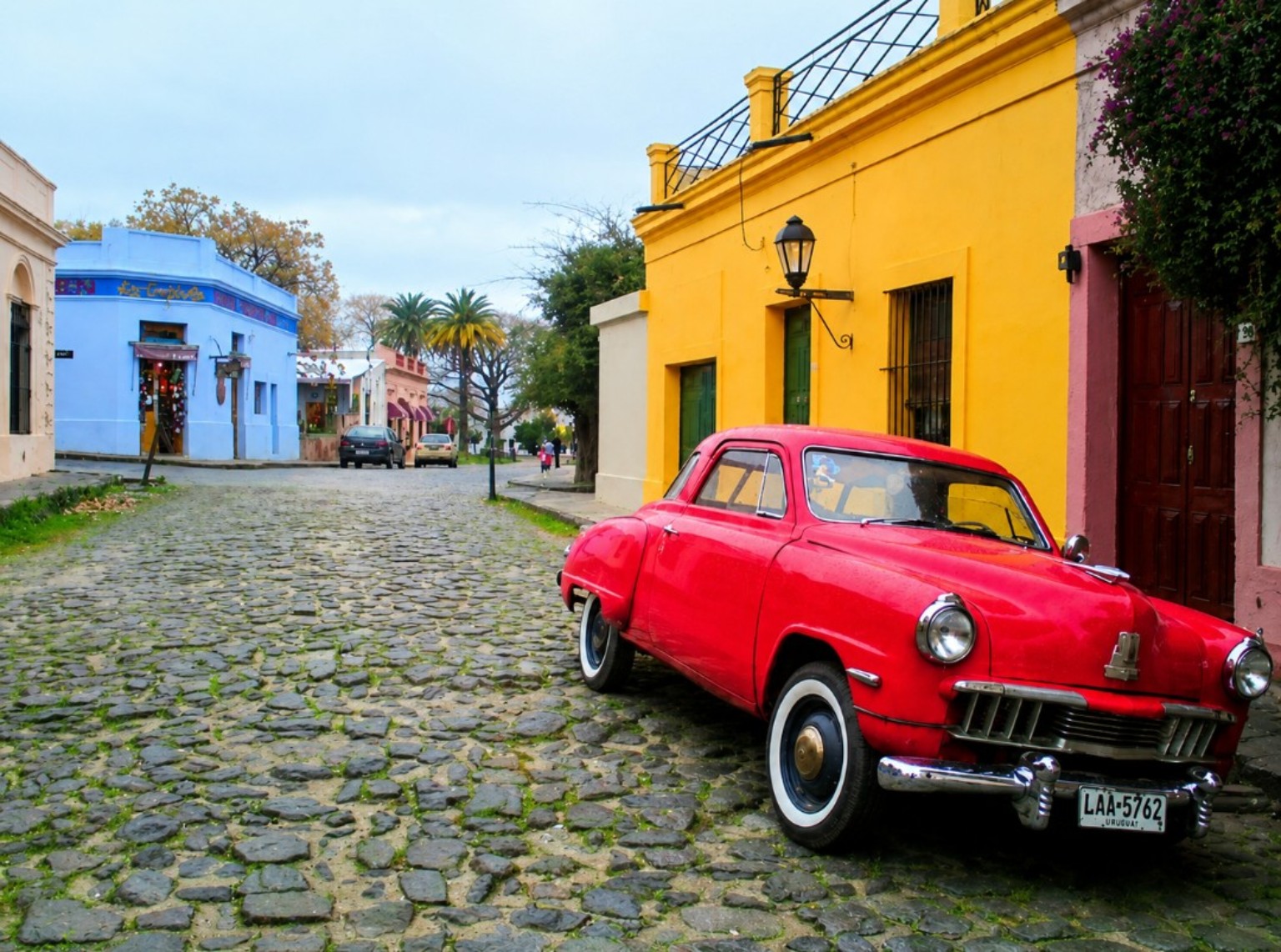 Vintage red car on a colourful cobbled street