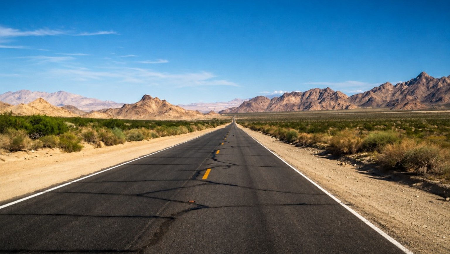 Desert road stretching toward distant mountains
